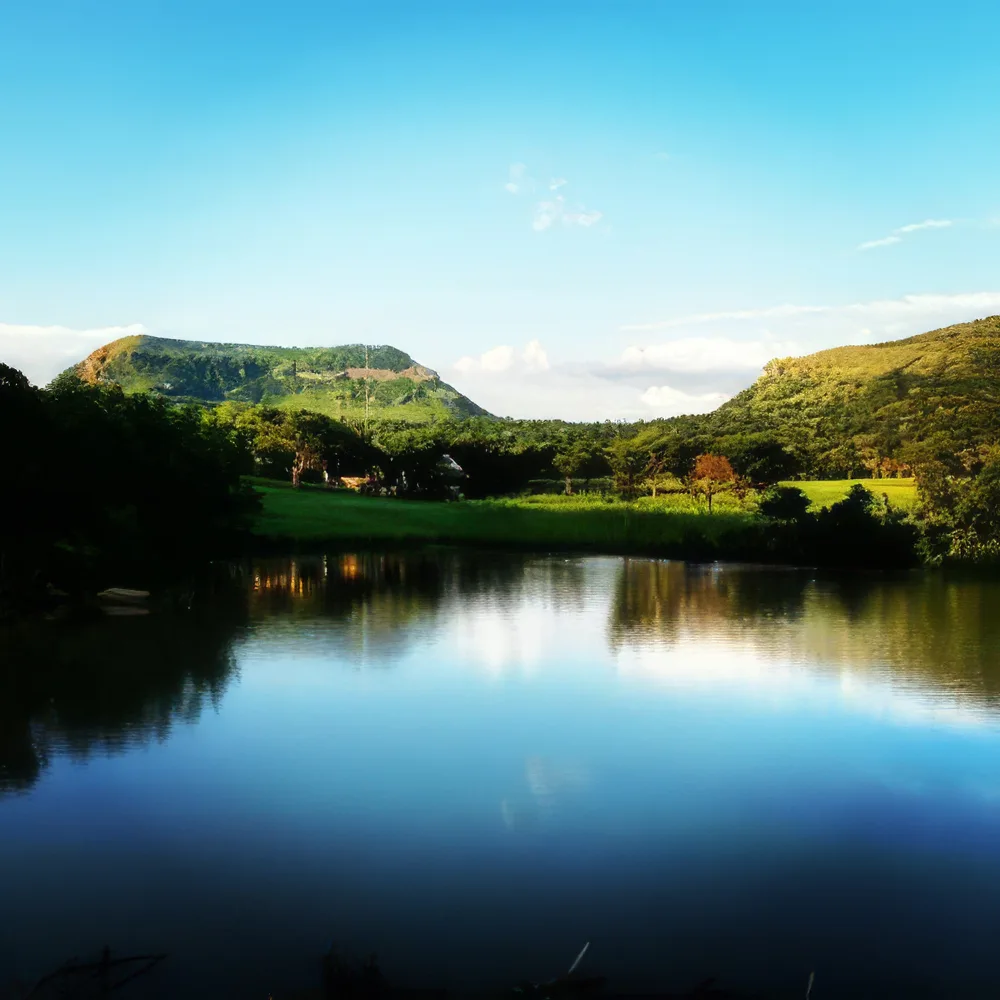 Tranquil dam reflecting mountain and green bush at Aloe Africa Hunting Safaris KwaZulu-Natal ranch